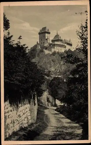 Ak Karlštejn Karlstein Mittelböhmen, Blick auf die Burg, Felswand, Wald, Hrad