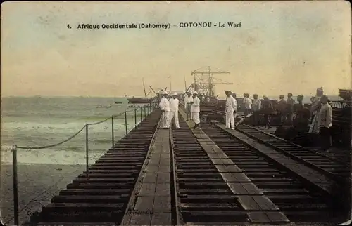 Ak Cotonou Dahomey Benin, Personen in Kolonialtracht auf Schiffsanleger