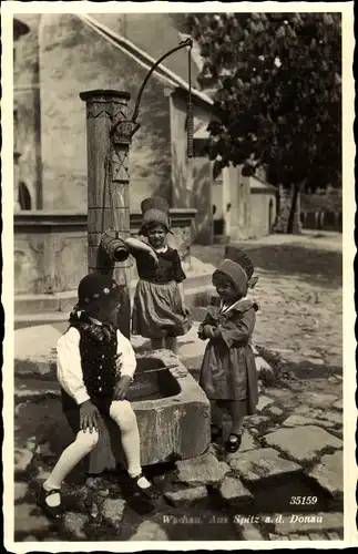 Ak Spitz an der Donau Niederösterreich, Wachau, Mädchen und Junge in Volkstrachten, Brunnen