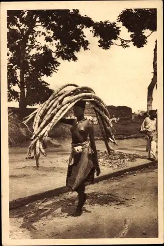 Ak Benin, Frau mit Rock bekleidet trägt Zuckerrohr auf dem Kopf