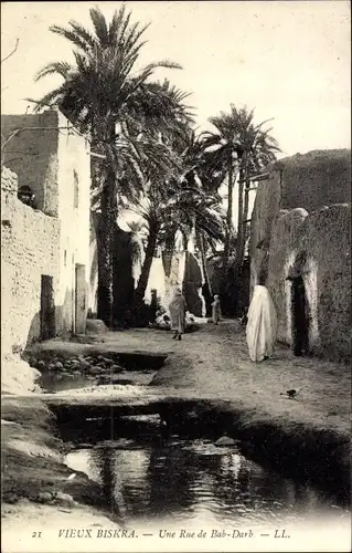 Ak Biskra Algerien, Vieux Biskra, Une Rue de Bab-Darb, Straße mit Wasser, Palmen