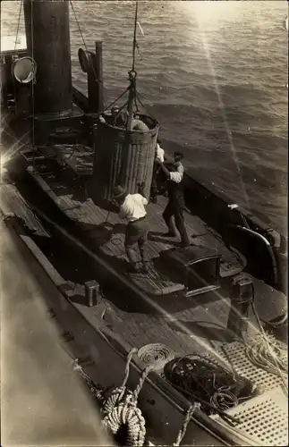 Foto Ak Korb mit Hüten wird zum Deck eines Dampfers herabgelassen