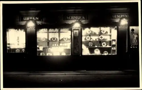 Foto Ak Unbekannter Ort, Uhren und Schmuckhandlung, Schaufenster bei Nacht
