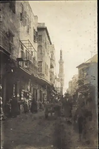 Foto Ak Straßenpartie einer Stadt, Turm, Passanten, Geschäfte