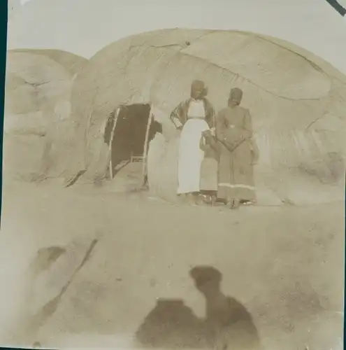 Foto Namibia, DSWA, Frauen der Herero vor einem Zelt, Schatten des Fotografs
