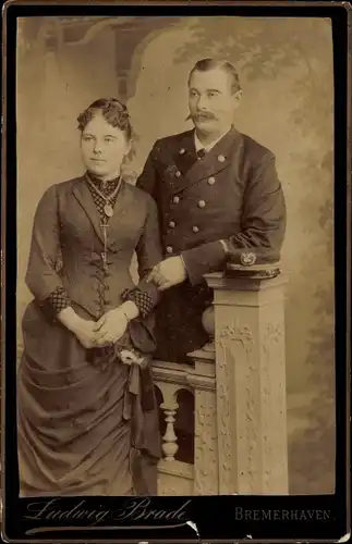 Kabinettfoto Mann in Uniform mit Frau, Korsett, Portrait, Fotograf Ludwig Brade, Bremerhaven