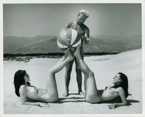 Foto Erotik Lilo Korenjak, Zwei Frauen liegend und ein Mann spielen mit Wasserball, Strand