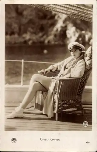 Ak Schauspielerin Greta Garbo, Portrait im Korbstuhl an Deck eines Bootes, Kapitänsmütze