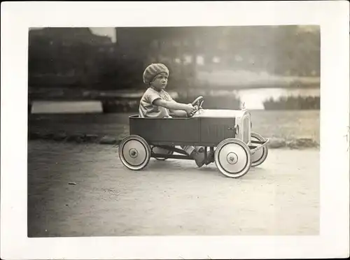 Foto Kind in Spielzeugauto, Tretauto