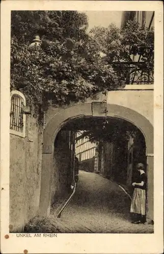 Ak Unkel am Rhein, Frau am Tor, Straßenpartie