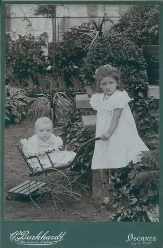 Foto Oschatz in Sachsen, Mädchen mit  Baby in einem Kinderwagen im Garten