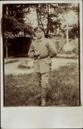 Foto Ak Deutscher Soldat in Uniform auf einem Friedhof, Portrait