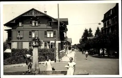 Foto Ak Kirchberg Kanton Bern, Straßenpartie, Mädchen am Brunnen