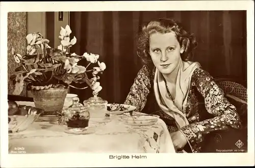 Ak Schauspielerin Brigitte Helm, Portrait am Tisch, Blumenvase