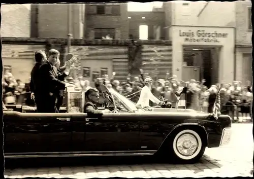 Foto John F. Kennedy winkend im offenen Automobil, Besuch in Berlin, Möbelfabrik Louis Görschner
