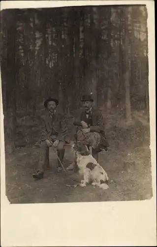 Foto Ak Zwei Männer mit Hund auf einer Bank am Waldrand