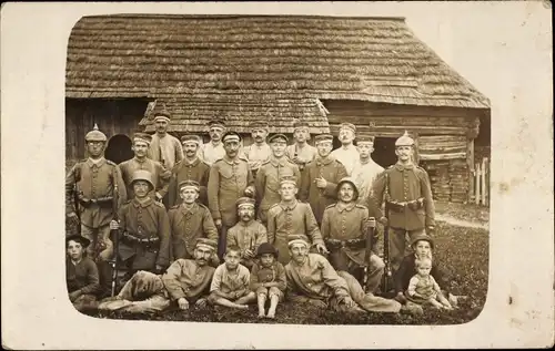 Foto Ak Deutsche Soldaten in Uniformen, Gruppenaufnahme vor Holzhütte