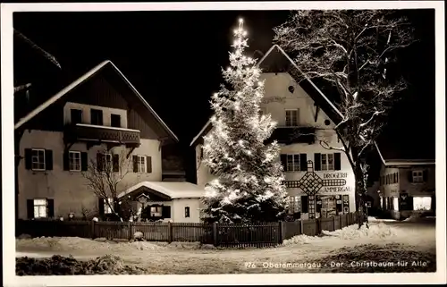 Ak Oberammergau in Oberbayern, Partie im Ort bei Nacht, beleuchteter Christbaum, Drogerie