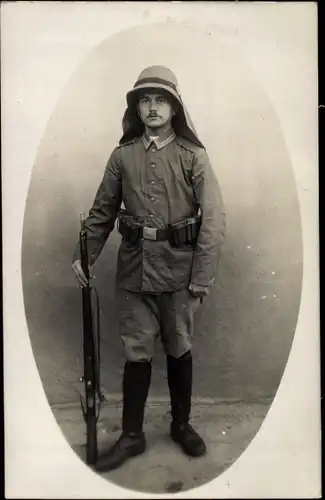 Foto Ak Deutscher Soldat in Uniform, Deutsche Schutztruppen in China, Helm mit Nackenschutz, Gewehr
