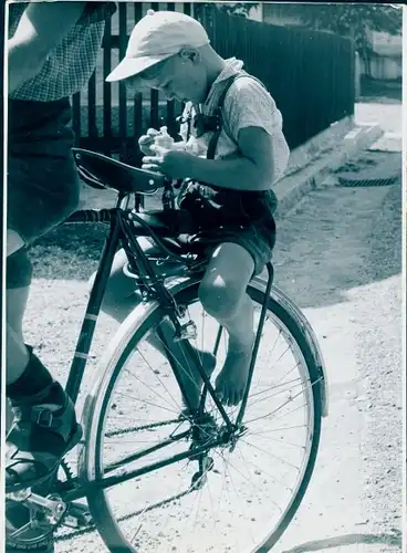 Foto Kind auf dem Gepäckträger eines Fahrrads, Lederhose, Schirmmütze