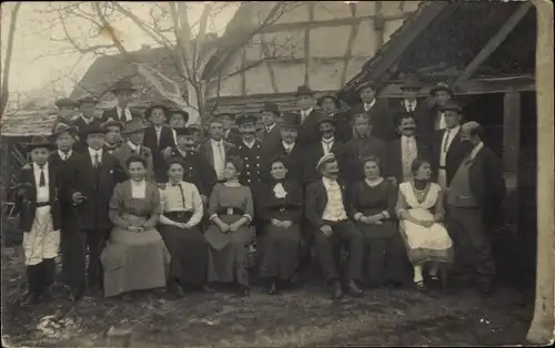 Foto Ak Unbekannter Ort, Gruppenaufnahme von Männern und Frauen, Uniformen
