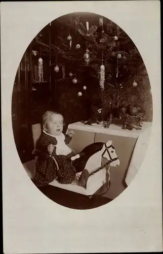 Foto Ak Kind auf Schaukelpferd reitend, Tannenbaum, Weihnachten