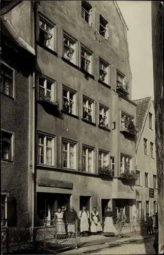 Foto Ak Wohnhaus, Anwohner, Männer und Frauen vor einer Handlung