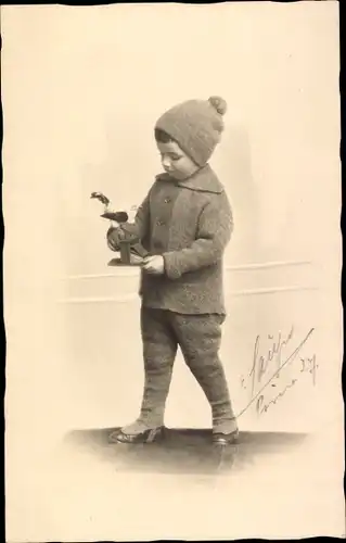 Foto Ak Kind, Standportrait, Spielzeug, Mütze
