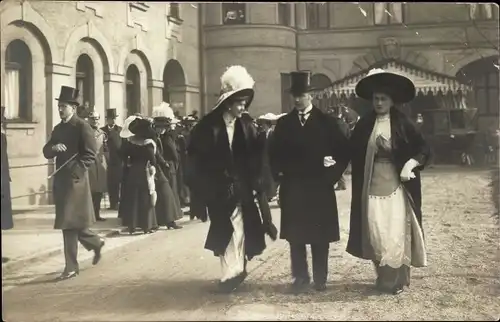 Foto Ak München Bayern, Mann im Mantel und Zylinder mit zwei eleganten Damen