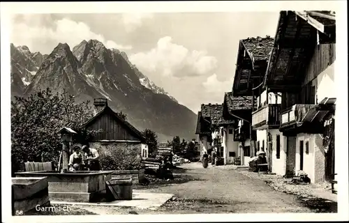 Ak Garmisch Partenkirchen in Oberbayern, Dorfstraße, Brunnen, Berge