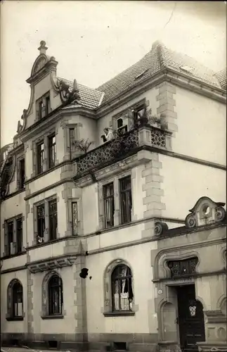 Foto Ak Heidelberg am Neckar, Partie an einem Wohnhaus, Frau auf einem Balkon
