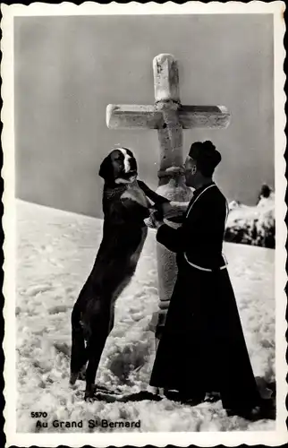 Ak St Bernard Sankt Bernhard Kanton Wallis, Pastor mit Berhardiner am Kreuz im Winter
