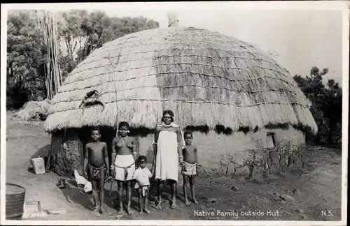 Foto Ak Native family outside hut, Afrikaner vor einer Lehmhütte