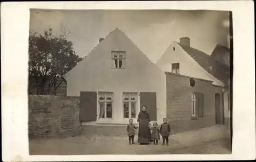Foto Ak Könnern im Salzlandkreis, Mutter mit Kindern vor einem Wohnhaus, Burgstraße 9