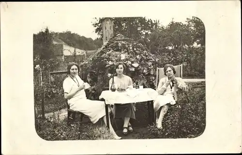 Foto Ak Drei Frauen an einem Tisch im Garten