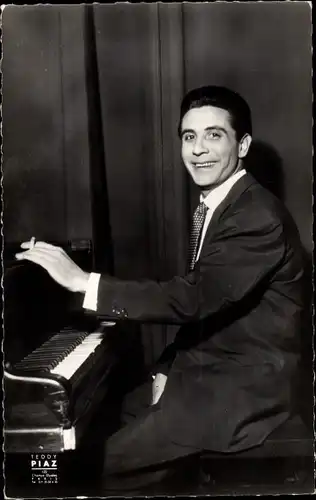 Ak Sänger Gilbert Becaud, Portrait mit Zigarette am Klavier
