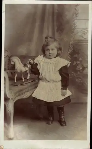 Foto Ak Kind mit Spielzeugpferd, Portrait