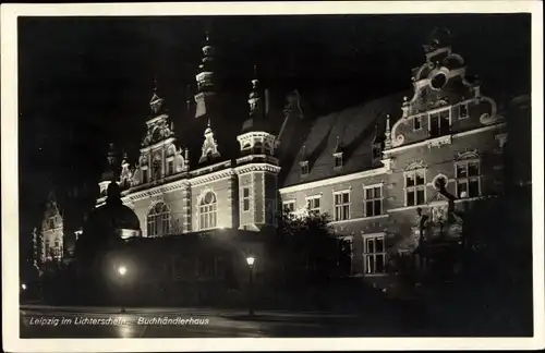 Ak Leipzig in Sachsen, Buchhändlerhaus im Lichterschein, Nachtaufnahme