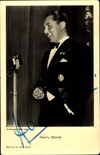 Ak Schauspieler Harry Gondi, Portrait im Anzug am Mikrofon, Brosche