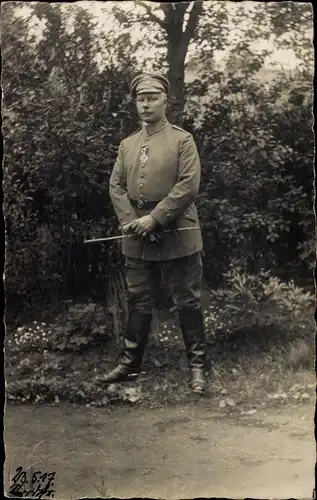 Foto Ak Deutscher Soldat im Garten stehend, Eisernes Kreuz, Schirmmütze