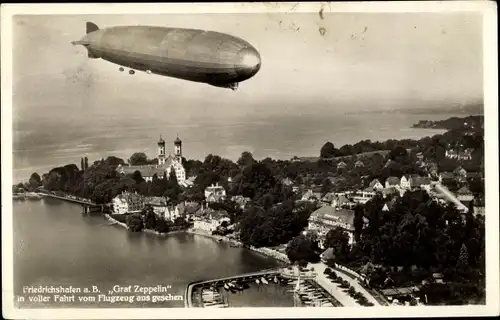 Ak Friedrichshafen am Bodensee, Luftschiff LZ 127 Graf Zeppelin über der Stadt, Fliegeraufnahme