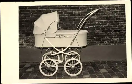 Foto Ak Kinderwagen vor einer Mauer