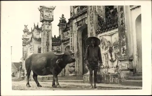 Foto Ak Vietnamese mit Rind, Im Hintergrund ein Tempel
