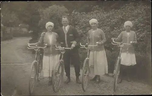 Foto Ak Mann und drei Frauen mit Fahrrädern