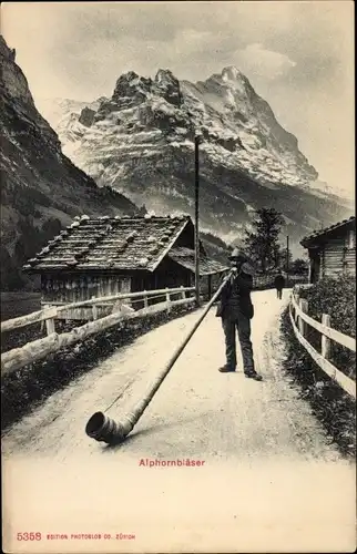 Ak Schweizerische Tracht, Alphornbläser, Im Hintergrund Berge