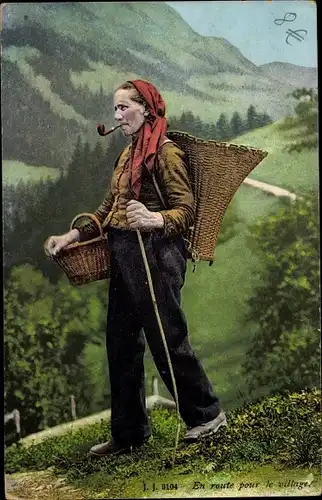 Ak En route pour le village, Frau in schweizerischer Tracht mit Pfeife