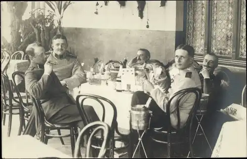Foto Ak Deutsche Soldaten in Uniform, Partie am Tisch, Zigarre, I. WK