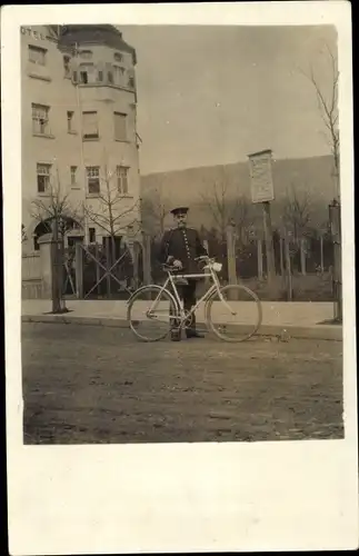 Foto Ak Mann in Uniform mit Fahrrad, Postbote