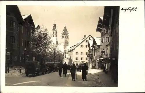 Foto Ak Kitzbühel in Tirol, Straßenpartie, Winteransicht, Kirchturm