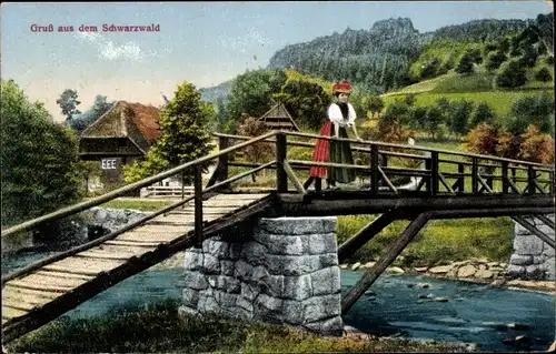 Ak Gruß aus dem Schwarzwald, Frau in Landestracht, Holzbrücke